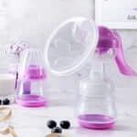 Extractor de leche manual maternal con cubierta antipolvo y accesorios.
